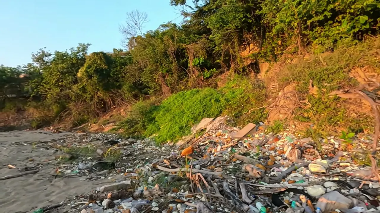 Botellas de plástico y basura acumuladas en la orilla