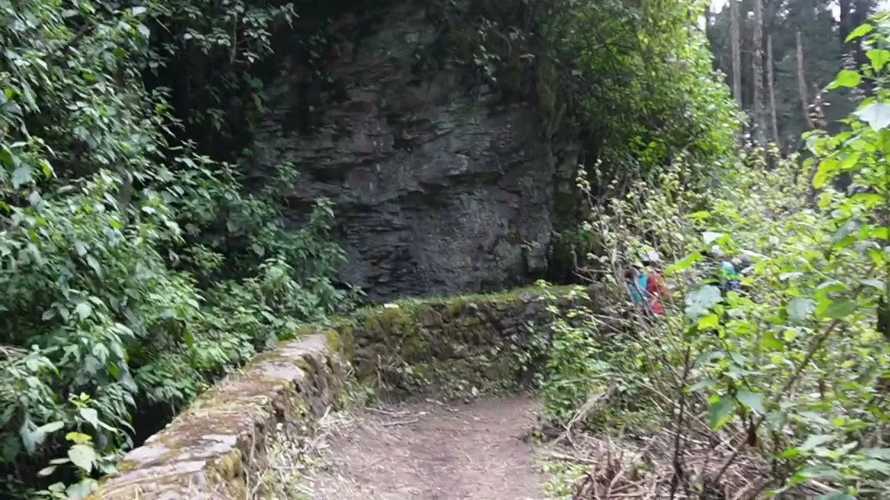 Un tramo angosto del sendero, junto a la pared de roca