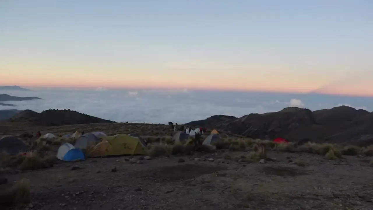 El campamento al atardecer, sobre un mar de nubes